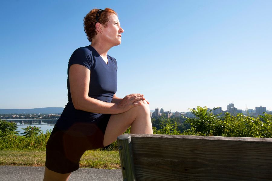 Woman stretching at a park bench