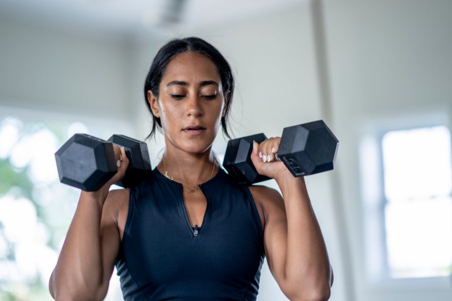 woman alternating between lifting light weights and stretching